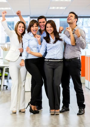 Successful business team at the office with arms up